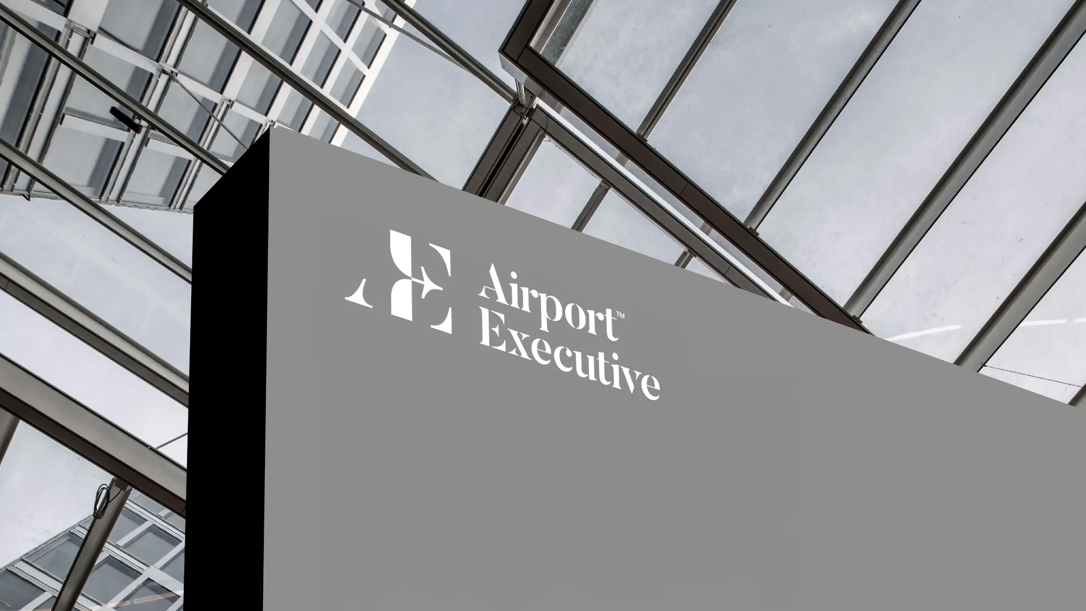 Airport Executive monogram and serif wordmark on environmental signage after the rebrand under new ownership